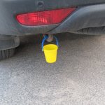 Why do drivers hang a small bucket behind the car?
