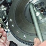 Unscrewing the flywheel mounting bolt