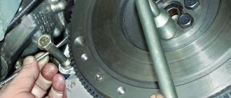 Unscrewing the flywheel mounting bolt